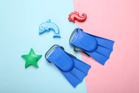 Childrens fins and toys for sandbox on a blue-pink pastel background. top viewの写真素材
