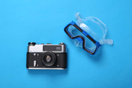 summer holidays. Diving mask and camera on blue background. Minimal beach vacation concept