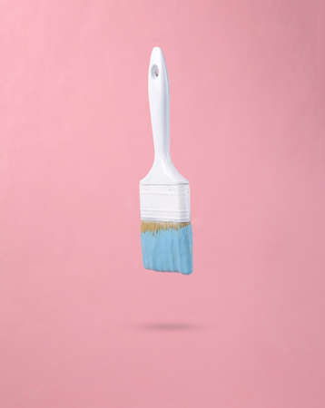 Levitating Paint brush with dripping turquoise paint on a pink background. minimal creative layout. concept art.の写真素材