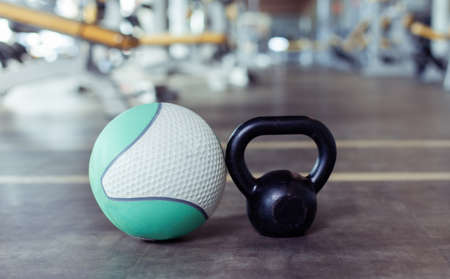 Kettlebell and medicine ball on the gym floor. Fitness, bodybuilding and functional training equipmentの写真素材