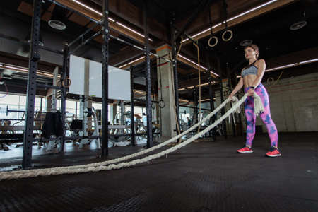 Fitness model with battle ropes in the gymの写真素材