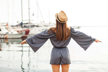 Feeling of freedom. Nice woman spread her arms to the sides in the yacht club. travel conceptの写真素材