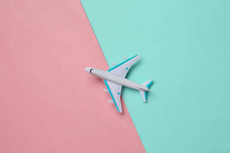 Toy passenger plane on a blue pink background. Voyage, travel concept. top view