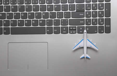 Toy plane on laptop keyboard. travel concept