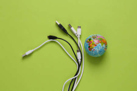 Different usb cable and globe on green background. Eco conceptの写真素材