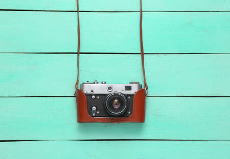 Retro camera in a leather cover on blue wooden background. top viewの写真素材