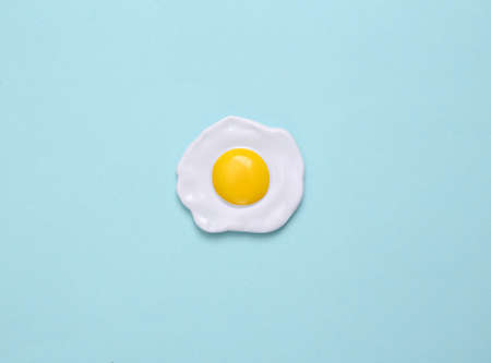 Plastic scrambled eggs on a blue pastel background. top view. minimal food conceptの写真素材