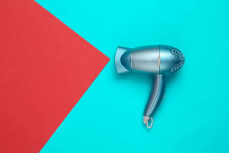 Hair dryer on red blue background. minimal layout. top viewの写真素材