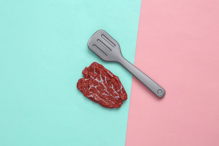 Plastic chop meat and fork on a blue-pink pastel background. top view. minimal food concept