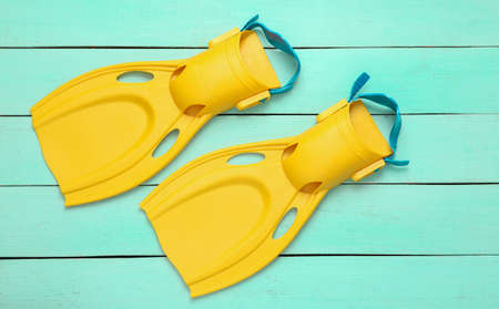 Yellow Diving fins on blue wooden background. top viewの写真素材