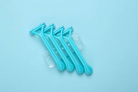 Set of disposable razors for depilation on blue background. top viewの写真素材