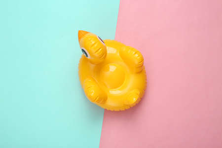 Inflatable duck on pink blue background. Minimal summer concept. top view.の写真素材
