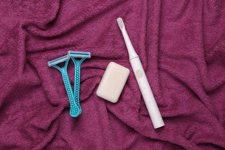 Products for your own hygiene on purple towel. top view. flat lay