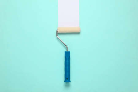Paint roller with white stripe on a blue background. home renovation conceptの写真素材
