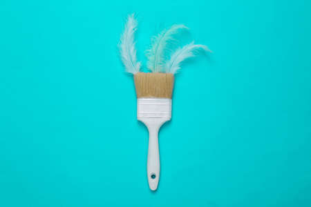 Paint brush with feathers on a turquoise background. top viewの写真素材