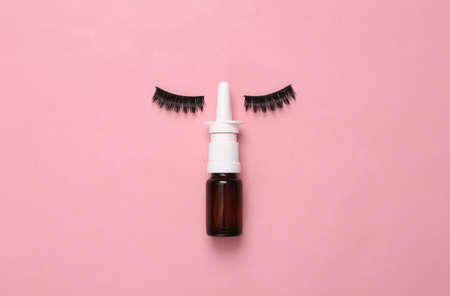 False eyelashes with nasal spray on pink backgroundの写真素材