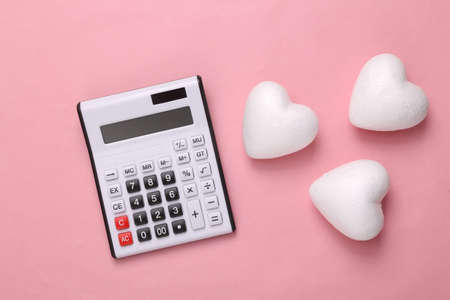 Calculator and hearts on a pink background. Romantic, love concept, valentine's dayの写真素材