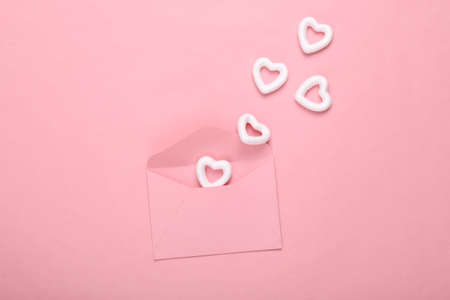 Envelope with white hearts on a pink background. creative layout. Love concept, happy valentines dayの写真素材