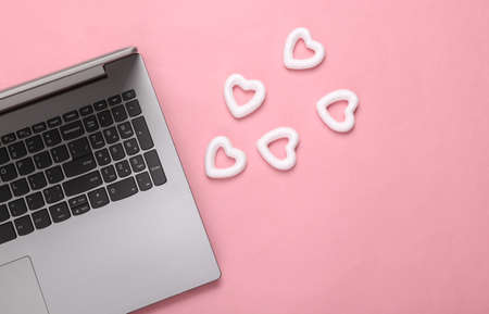 Laptop with hearts on a pink background