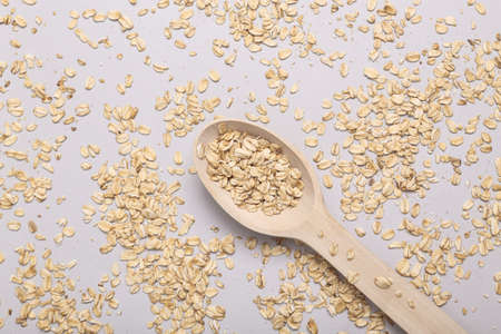 Wooden spoon with dry oatmeal on gray backgroundの写真素材