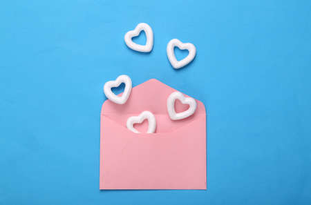 Envelope with white hearts on blue background. creative layout. Love concept, happy valentines day