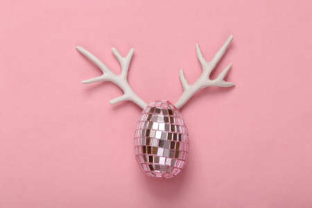 Creative Easter layout. Mirror egg with antlers on a pink background. party conceptの写真素材