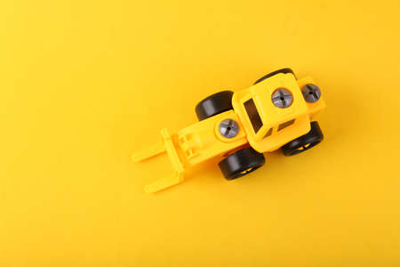 Toy yellow forklift on yellow background. top viewの写真素材
