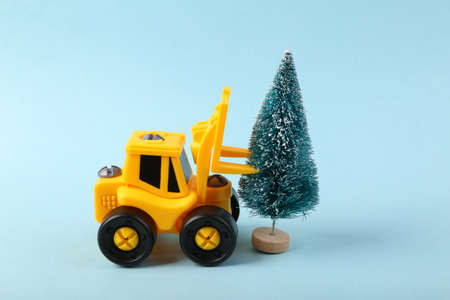 Toy forklift with christmas tree on blue backgroundの写真素材