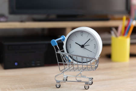 Shopping trolley with clock on computer table. online shopping