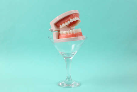 Jaw model in cocktail glass on blue background. fresh ideas. Minimal party concept, creative layout