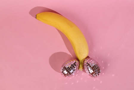 Panan with mirrored eggs on a pink background. male genital shape