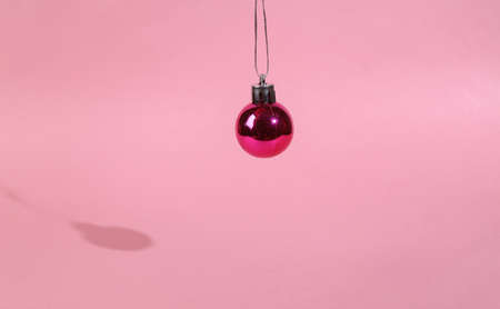 Christmas ball toy on a pink background. Minimal christmas conceptの写真素材