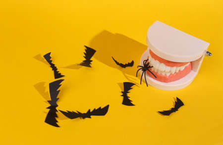 Jaw with bats and spider on yellow background. halloween minimal layoutの写真素材