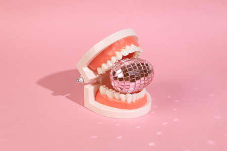 Jaw with mirrored egg on a pink background. easter minimal composition