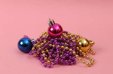 Christmas balls toys and garlands on a pink background