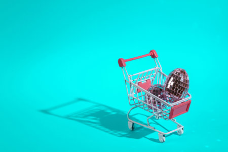 Mini shopping cart with mirrored eggs on turquoise backgroundの写真素材