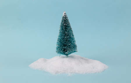 Christmas tree in a snowdrift on a turquoise background. minimal layout
