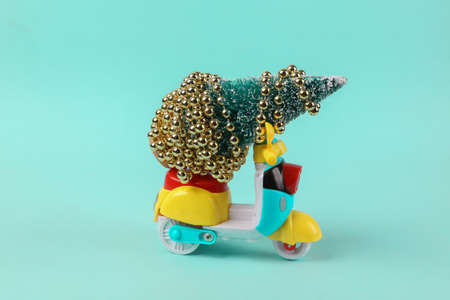 Mini scooter with christmas tree on turquoise backgroundの写真素材