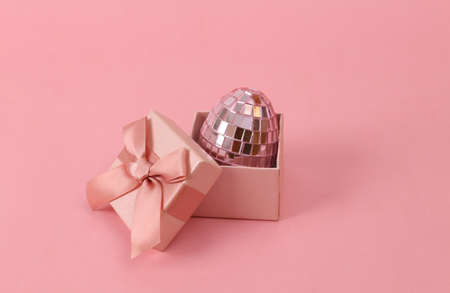 mirror egg in a gift box on a pink background Easter concept