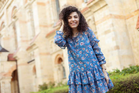Cute smiling curly woman in the city