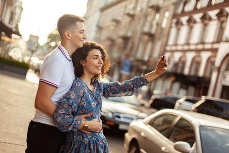 Young lover spends time together, taking selfie in cityの写真素材