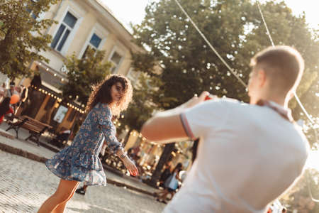 The guy takes pictures of the fun curly-haired girl in the cityの写真素材