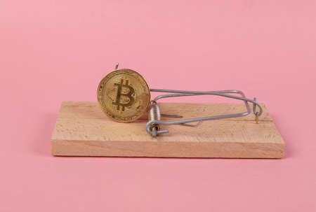 Mousetrap with bitcoin on pink background. Cryptocurrency risksの写真素材