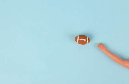 Hand doll holding rugby ball on blue background, Minimal sport conceptの写真素材