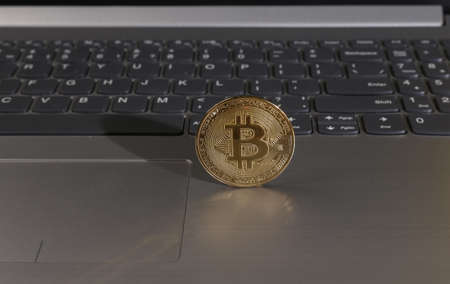 Bitcoin on laptop keyboard. Cryptocurrency, mining, e-commerce concept