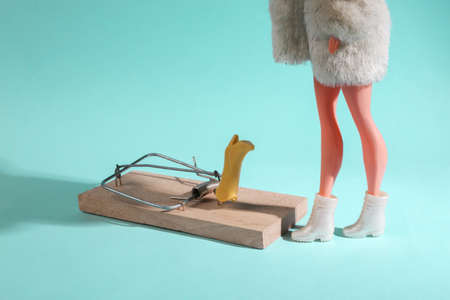 Tempting offer. shopping cult. sale. The doll is standing near the mousetrap with new boots on a blue background. minimal layoutの写真素材