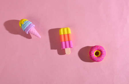 Plastic model of a donut and ice cream on pink backgroundの写真素材