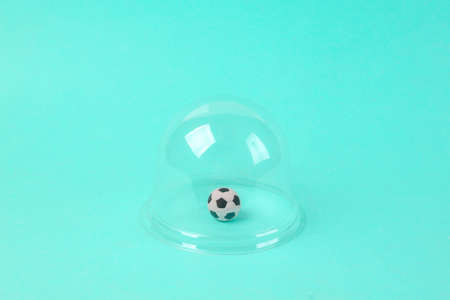 Soccer ball under a transparent dome on a blue background. isolation conceptの写真素材