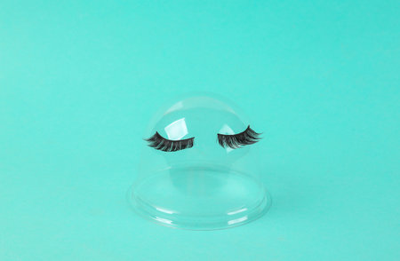 Transparent dome with false eyelashes on blue background. minimal layoutの写真素材