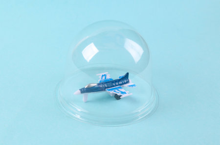 Fighter aircraft under transparent dome on blue background. protection concept. minimal layout